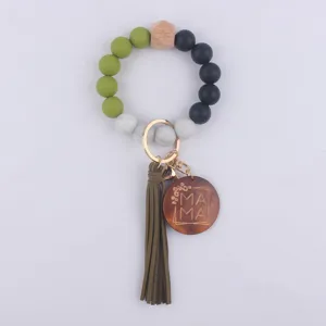 Silicone bead wristlet keychain detail showing green and black beads with wood charm.