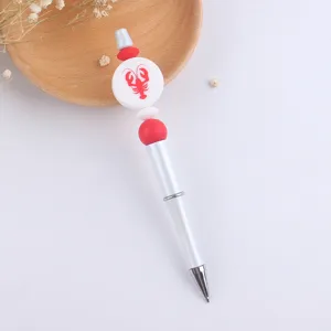 Close up of DIY beaded ballpoint pen featuring lobster charm and colorful silicone beads details.