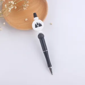 DIY beaded ballpoint pen with silicone charm featuring cute forest silhouette design.