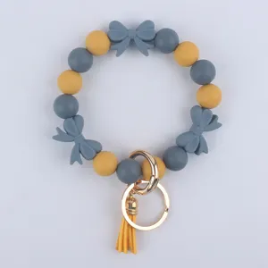 Portachiavi braccialetto in perline di silicone con fiocchi e nappe carini per donna.