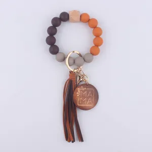 Silicone beaded keychain bracelet with wood charm and leather tassel for women everyday use.