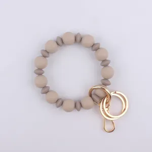 Detalle en primer plano del llavero pulsera de cuentas de silicona con anillas doradas.