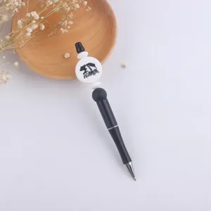 Closeup detail of the DIY beaded ballpoint pen featuring bear design and sleek black body.