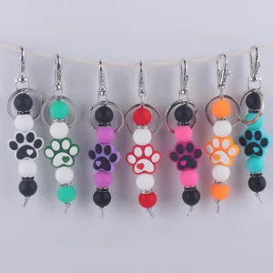 Primer plano detalle de llavero de pata de perro con cuentas de silicona coloridas y metal.