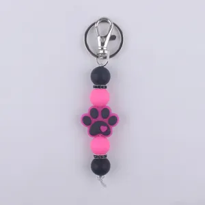 Llavero de cuentas de silicona con bonito colgante de huella de perro, negro y rosa.