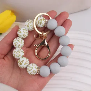 Silicone bead wristlet keychain detail shot showing leopard print and solid grey beads with gold clasp.