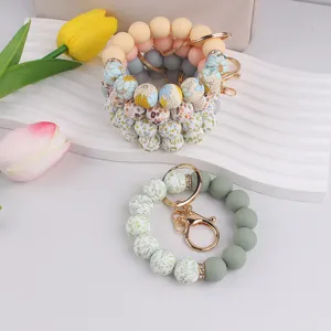Silicone beaded wristlet keychain featuring vibrant floral print and solid beads, cute bag charm.