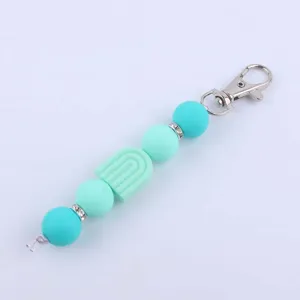 Silicone bead keychain DIY accessory with cute rainbow charm, mint green and turquoise colors.