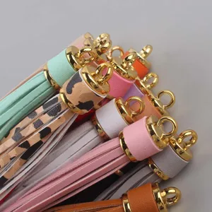 Nappe in ecopelle colorata con tappi in metallo dorato, perfette per ciondoli di borse e accessori.