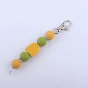 Detailed shot of DIY silicone bead keychain with rainbow charm and metal clasp accessory.