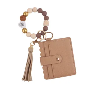 Portachiavi con braccialetto di perline e portafoglio porta carte con nappa da donna.