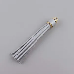 Dettaglio nappina in pelle argentata con tappo metallico dorato per creazione di gioielli fai da te.
