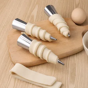 Set of stainless steel cream horn molds with pastry dough on a wooden cutting board
