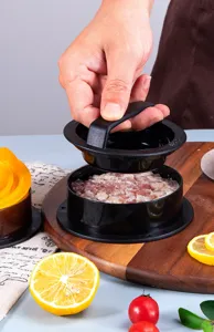 Close-up of black manual hamburger patty press making a meat patty on a wooden board.