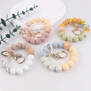 Silicone bead wristlet keychain with wooden octagonal beads and floral print design.