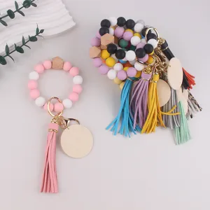 Silicone bead wristlet keychain bracelet with leather tassel and blank wood disk for gifts.
