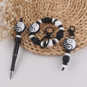 Zwarte en witte siliconen kralen pen armband sleutelhanger set met zon en maan patroon.