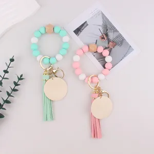 Silicone beaded keychain bracelet with leather tassel and wood charms for keys and bags.