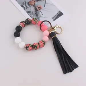 Pulsera llavero de cuentas de silicona con borla negra y anillo de muñeca colorido.