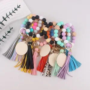 Silicone bead key bracelet with leather tassel and wood disc, colorful wrist keychain design.