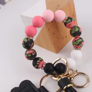 Silikon Perlen Schlüsselanhänger Armband mit Blumenmuster Perlen und edlem Goldmetall.