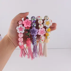 Silikon Perlen Schlüsselanhänger Armband mit süßen Blumen Charms und Quaste für Damen.