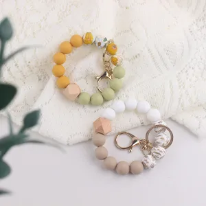 Silicone beaded wrist keychain with wooden octagonal beads and metal clasp for keys.