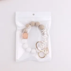Silicone beaded keychain bracelet detail shot, featuring wooden and floral printed beads.