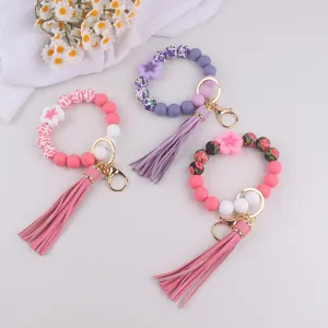 Silikon Perlen Armband Schlüsselanhänger mit Quaste und Blumen Anhänger Detail für Damen Accessoire.