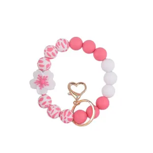 Silicone beaded keychain bracelet with cute flower charm and gold heart clasp for women daily use.