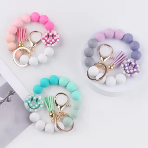 Colorful silicone bead keychain with cute smiley face and tassel pendant, stylish bag accessory.