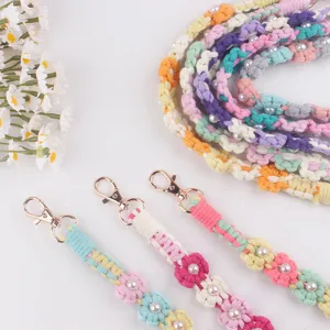 Detailed closeup of handmade crocheted colorful daisy flower pearl strap with metal lobster clasp.