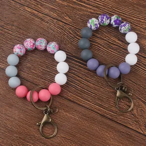 Silicone beaded wristlet keychain with floral print charms and metal clasp for women and girls.