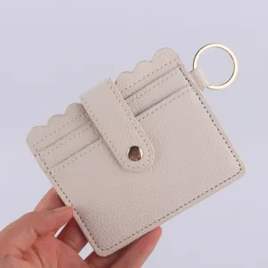 Beige PU leather cardholder with scalloped edge snap closure and golden key ring detail.