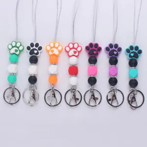 Close up of colorful silicone paw print keychain with beads and metal lobster clasp detail