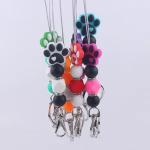 Silicone cartoon dog paw keychain detail shot, colorful beaded pendant bag charm accessory.