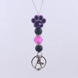 Cute silicone paw print keychain detail, black pink beaded charm with metal clasp for bags.