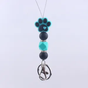 Close-up detail of the silicone dog paw bead, showing fine texture, vibrant color and metal clasp.