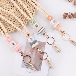 Houten kraal lanyard sleutelhanger met siliconen madeliefje en boek bedels, stijlvolle tassel.