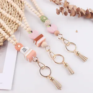 Detailed shot of wooden bead lanyard with cute silicone book and daisy charms for ID badge.