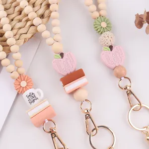 Teacher beaded lanyard detail showing cute silicone apple, book and daisy charms for keys.