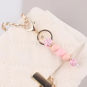 Handgefertigter DIY Perlen Taschenanhänger Schlüsselanhänger mit rosa Perlen Gold.