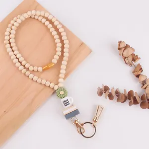 Houten kralen lanyard detail met siliconen madeliefje en boekenhangertje met metalen karabijnhaak.