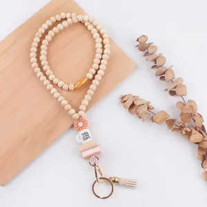 Wooden bead lanyard detail showing cute silicone daisy charm, mini books, and tassel keychain.