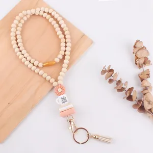 Gedetailleerd zicht op houten kralen lanyard met siliconen madeliefje en boek hanger.