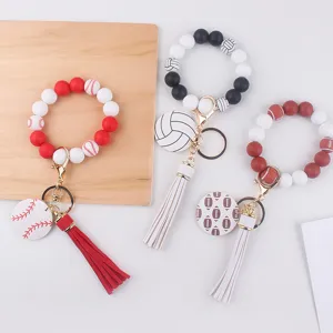 Détail de porte-clés bracelet en perles de silicone avec thèmes sportifs, gland en cuir PU et métal.