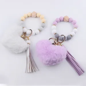 Portachiavi da polso con perle di silicone, ciondolo a cuore morbido e nappa in pelle.
