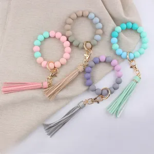 Close-up detail shot of colorful silicone beaded keychain bracelets with PU leather tassels.