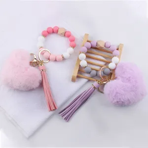 Portachiavi da polso in perole di silicone con nappa in pelle PU e ciondolo cuore in peluche.