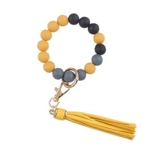 Silicone beaded wristlet keychain with PU leather tassel and gold metal hardware for women.